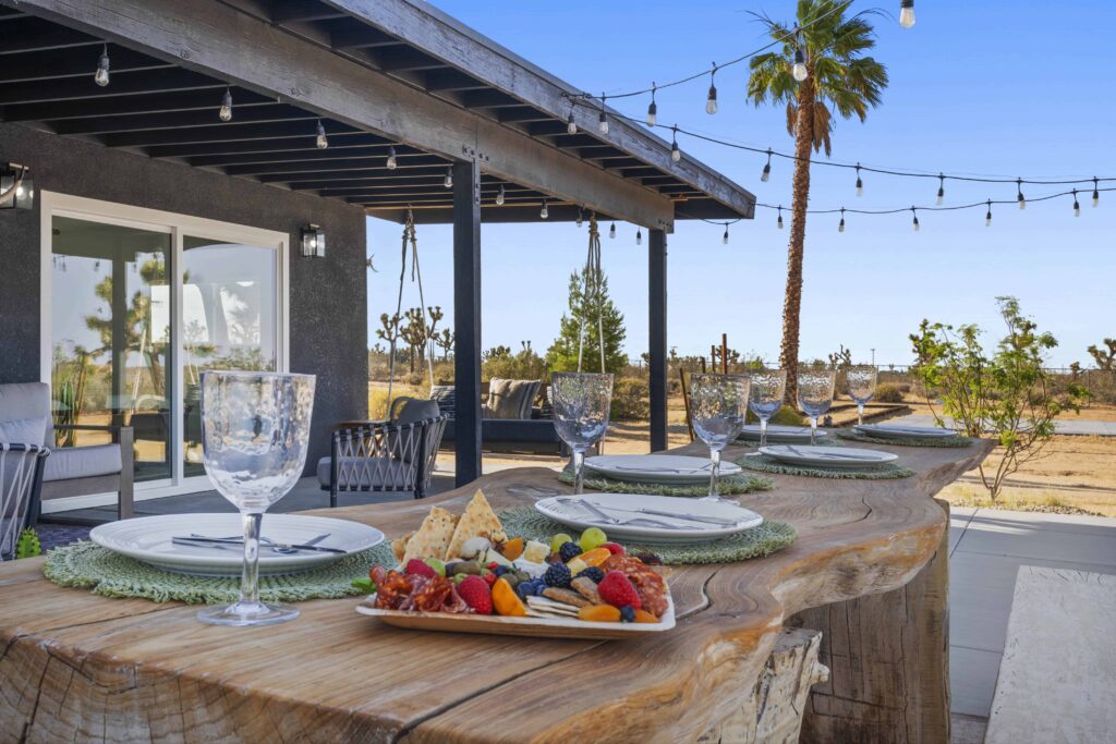 Outdoor dining table set for a meal on the covered patio at The Desert Shadow